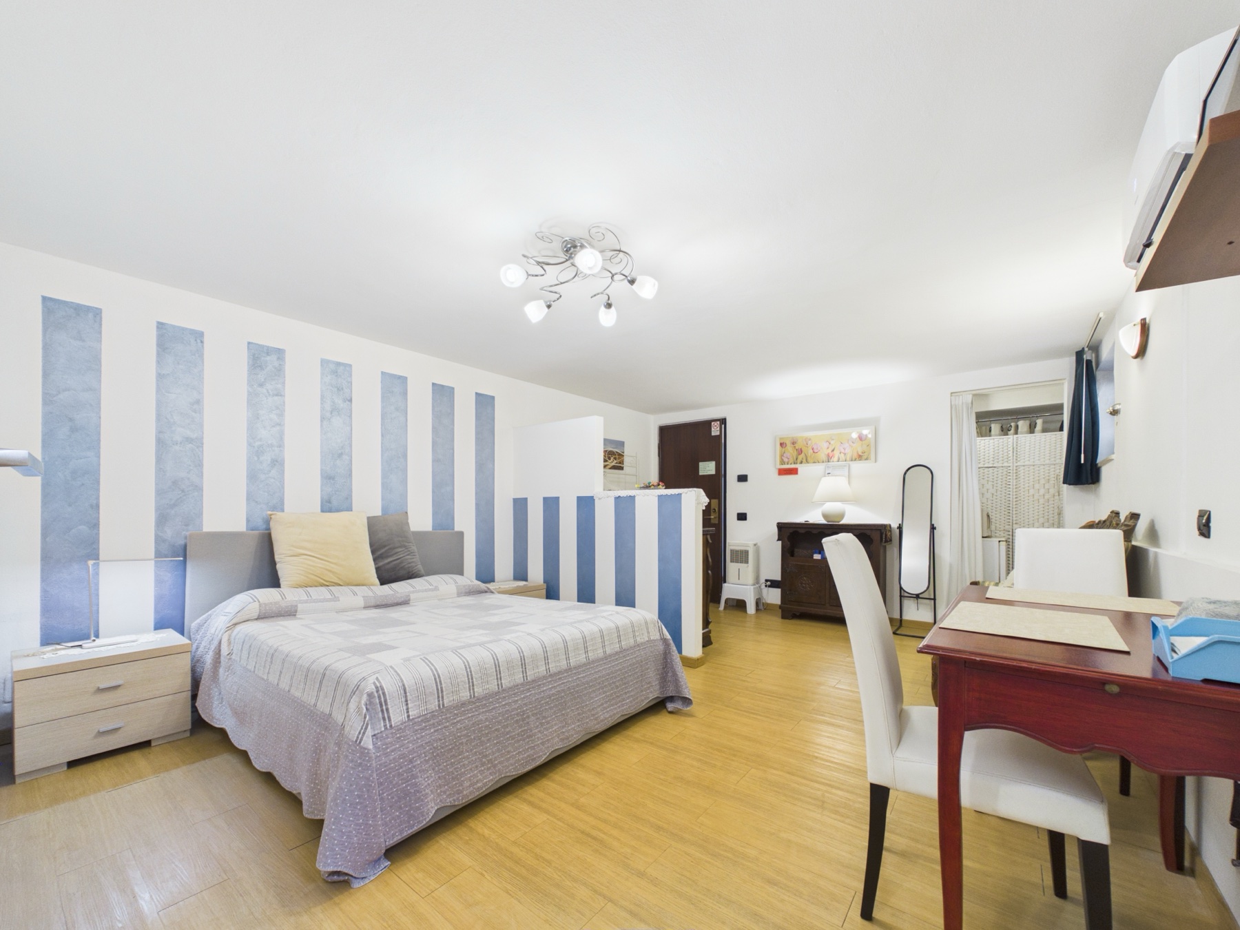 Camera da letto con parete a righe azzurre